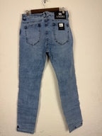 These Amiri distressed blue jeans feature prominent white paint splatters and a large embroidered logo patch.