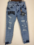 These Amiri distressed blue jeans feature prominent white paint splatters and a large embroidered logo patch.