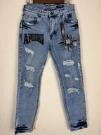 These Amiri distressed blue jeans feature prominent white paint splatters and a large embroidered logo patch.