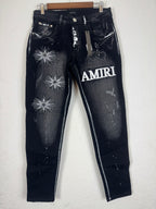 Amiri brand jeans featuring distinctive white starburst embroidery and a prominent logo patc