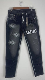 Amiri brand jeans featuring distinctive white starburst embroidery and a prominent logo patc